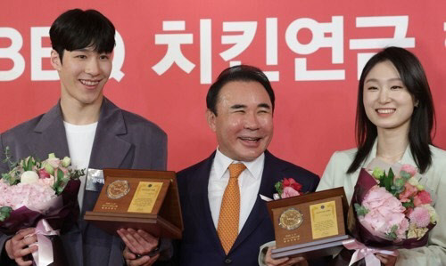 2022 베이징동계올림픽 금메달리스트인 황대헌과 최민정이 21일 오전 서울 중구 롯데호텔에서 열린 제너시스 BBQ 치킨연금 행복전달식에서 윤홍근 회장에게 '치킨연금'을 받은 뒤 기념촬영을 하고 있다. <연합뉴스>